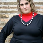 Fat women posing against brick wall