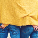 Back side view closeup cropped photo of couple touching each another ass. Denim fashion style. Sexy couple embracing and hugging