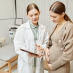 Doctor Talking to Pregnant Woman in Clinic
