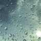 Raindrops on a window with a blue sky