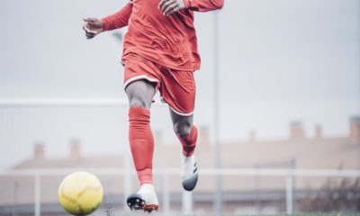 African soccer player with red outfit playing soccer.
