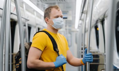 European man wears surgical mask, commutes in metro or underground, carries backpack
