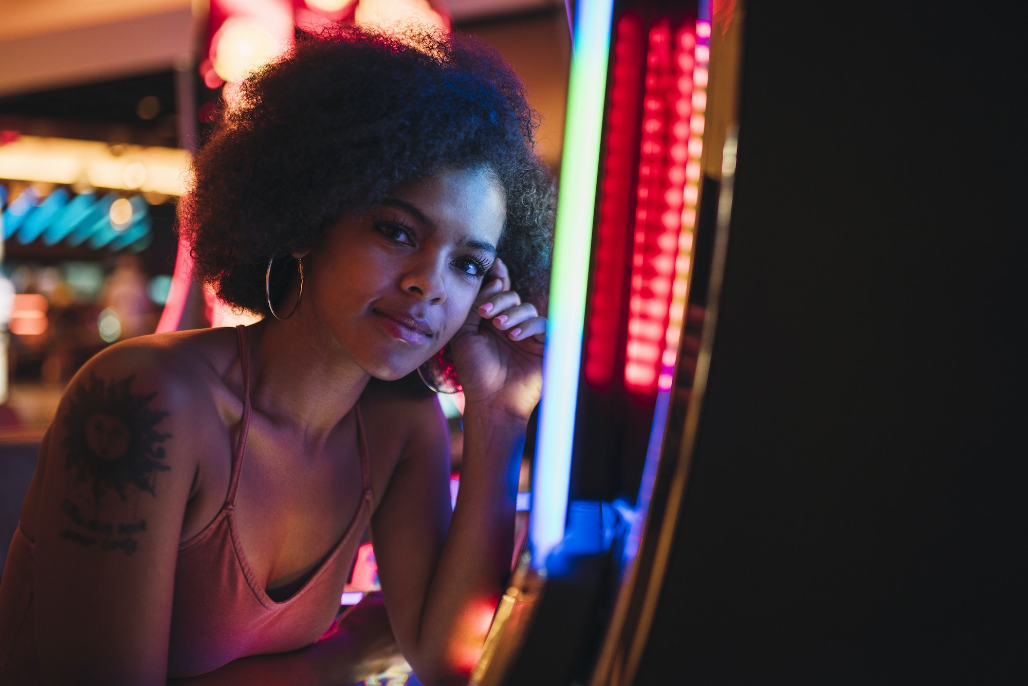 USA, Nevada, Las Vegas, portrait of young woman at slot machine in a casino