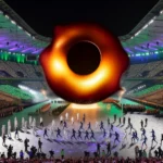 DALL·E 2024-02-15 16.10.19 – A humorous and surreal scene of a black hole forming in the center of the Stade de France during the opening ceremony of the Olympics. Athletes and sp