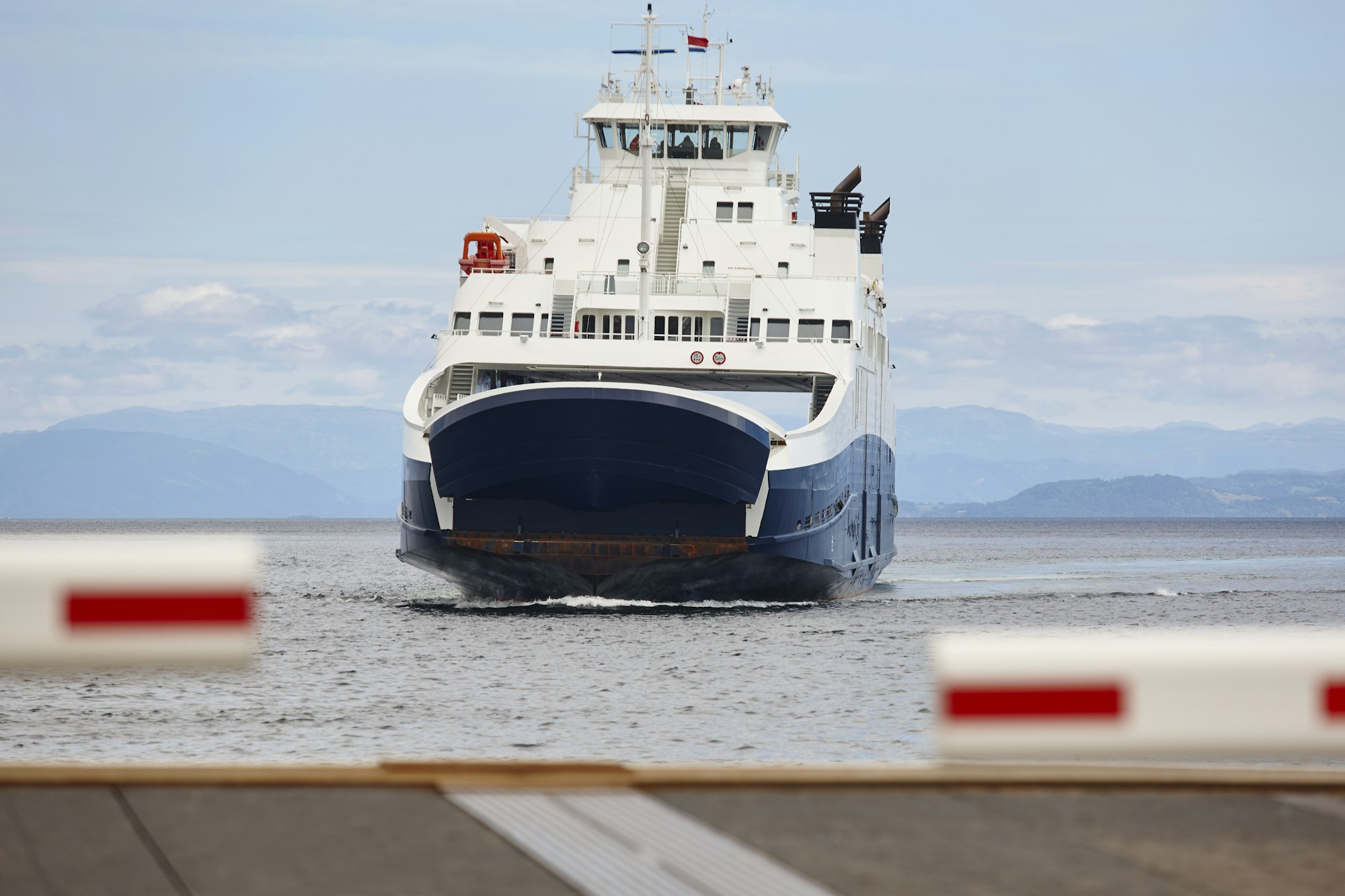 Norwegian car ferry landing at port. Closed barrier. Horizontal