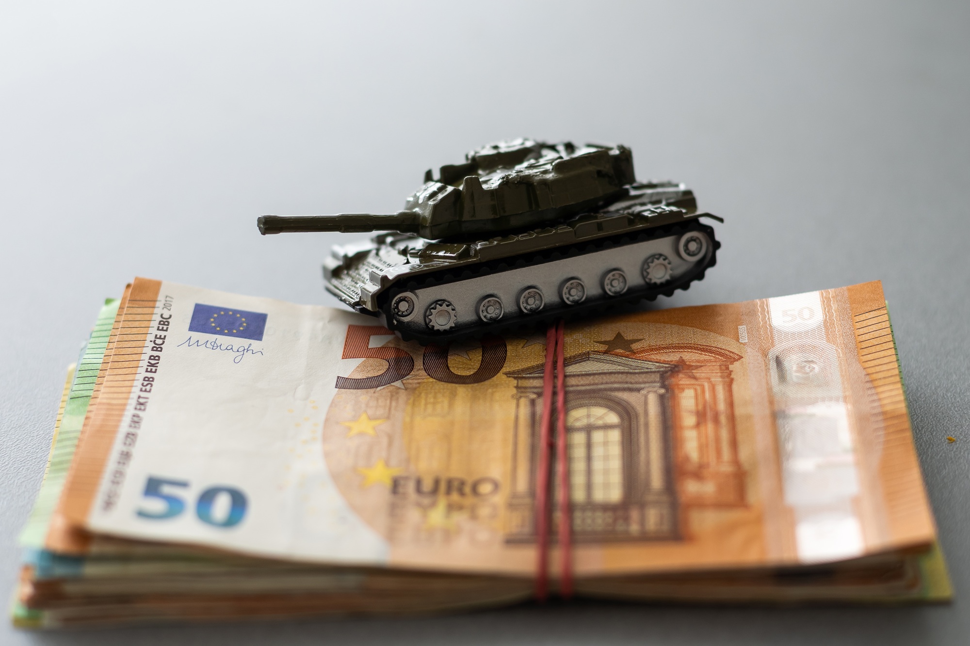 Economic crisis concept. Toy military tank on euro banknotes. War conflict in Ukraine, economic